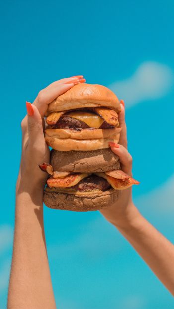 Обои 640x1136 бургер, девушка, руки, небо, сыр, котлета, булочка, еда